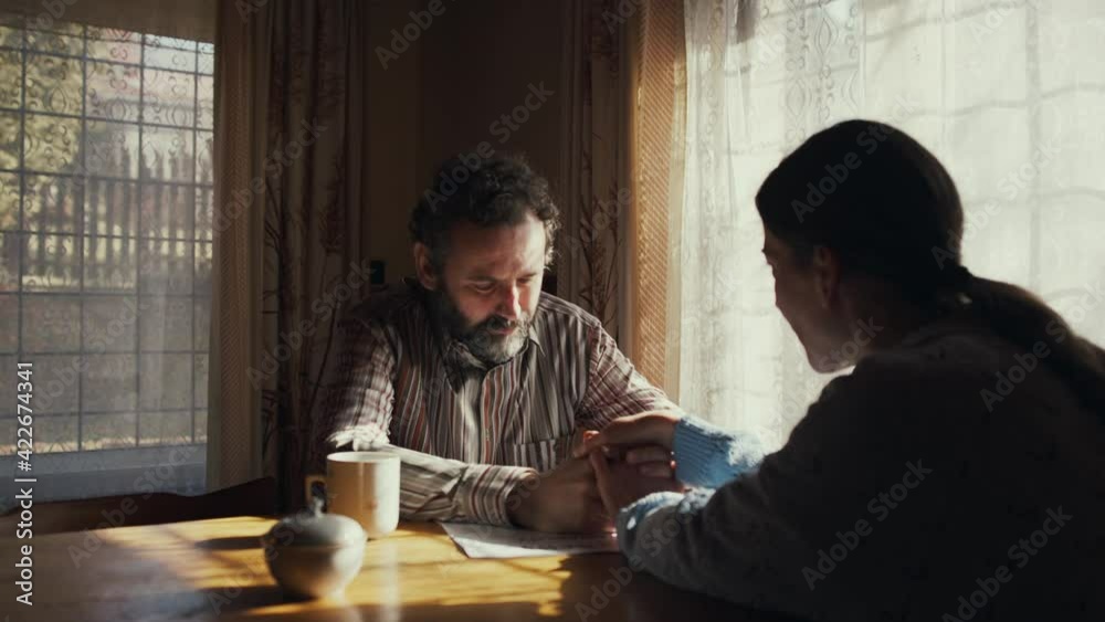 Unhappy poor couple comforting each other indoors at home, poverty concept.