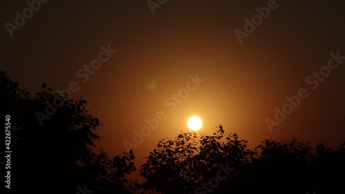 time lapse view of Beautiful bright sunrise behind silhouette trees .concept for Sun rise from behind silhouette mountains, time lapse of sunrise, time laps of sunset , sun rise time lapse , big sun.