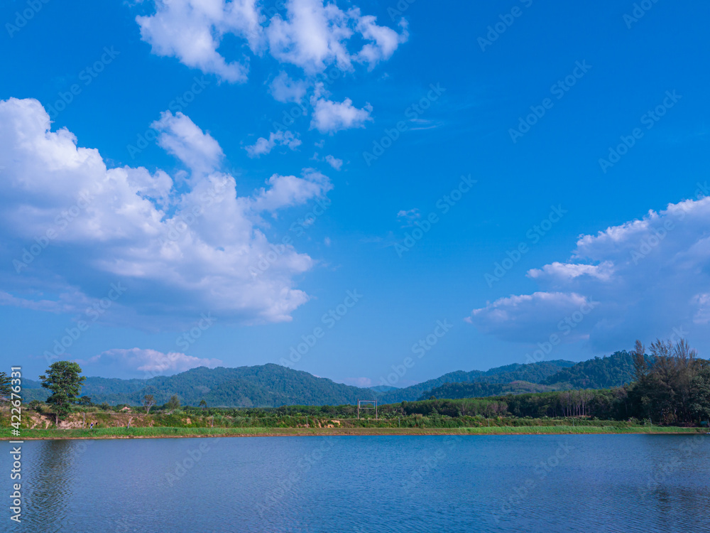 landscape mountain and lake panoramic view with beautiful cirrocumulus clouds popping above lush green mountain in bright clear sunny summer season, blue skycape natural background landscape mountain and lake panoramic view with beautiful cirrocumulus clouds popping above lush green mountain in bright clear sunny summer season, blue skycape natural background