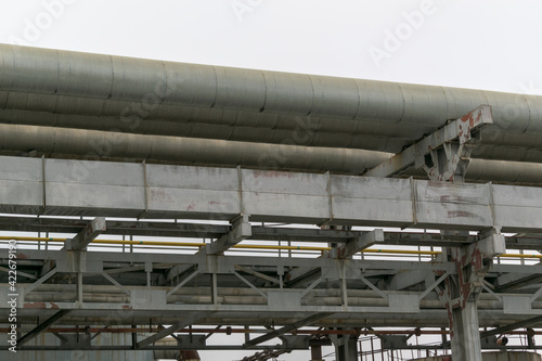 Pipes on metal supports. The background is the sky. The concept of a plant, a thermal power plant, a centralized water supply system.