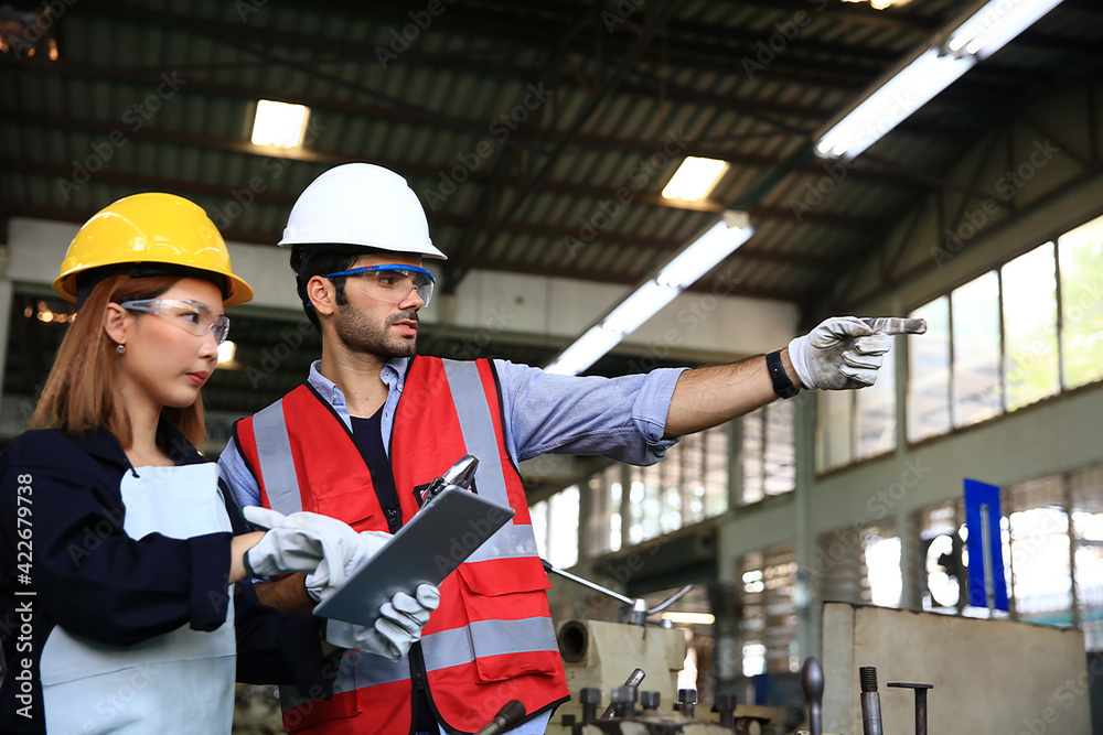Suppervisor and engineer wearing safety unform and equipment disucsion at work shop or factory Suppervisor and engineer wearing safety unform and equipment disucsion at work shop or factory