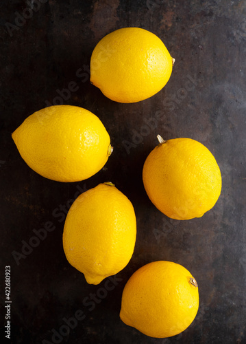 Ripe bright lemons on the dark rustic background. Selective focus. Shallow depth of field.