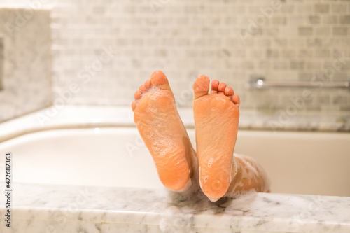 The legs of the children in the foam. Children taking a bath. Hygienic procedure, cleanliness concept.