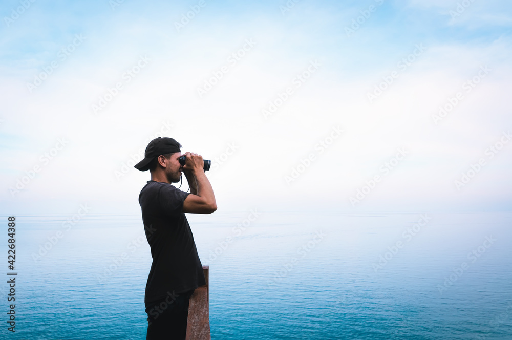 Obraz premium Man with binoculars looking forward through the fog, Koh Phangan, Thailand