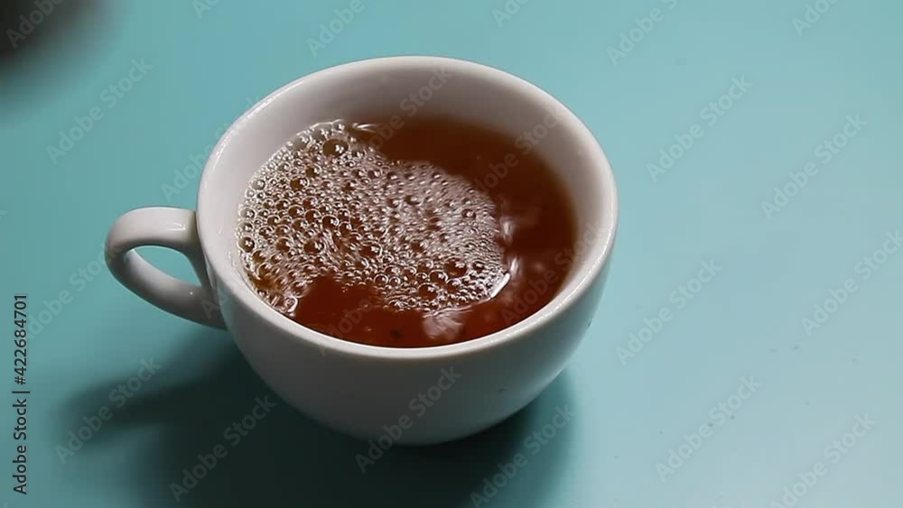 Tea being poured into white tea cup Tea being poured into white tea cup