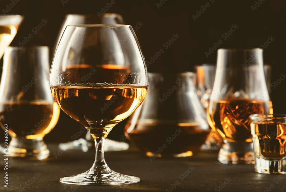 Hard strong alcoholic drinks and distillates in glasses in assortment: vodka, cognac, tequila, scotch, brandy and whiskey, grappa, liqueur, vermouth, tincture, rum. Brown background Hard strong alcoholic drinks and distillates in glasses in assortment: vodka, cognac, tequila, scotch, brandy and whiskey, grappa, liqueur, vermouth, tincture, rum. Brown background