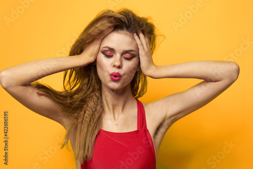 emotional woman wavy hair bright makeup lifestyle yellow background