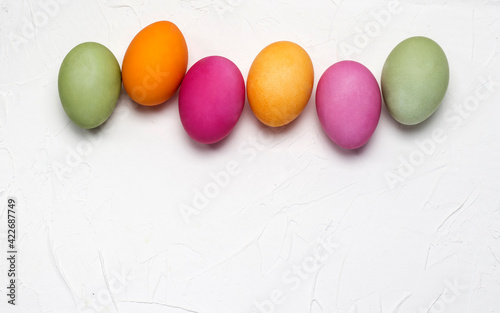 bright easter eggs on a white textured background with a copy of the space