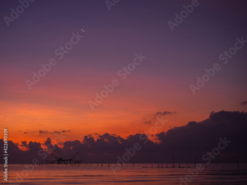 Silhouette photo of fisherman trap fish in front of sunrise scene at famous Pak Pra Phatthalung provience Thailand