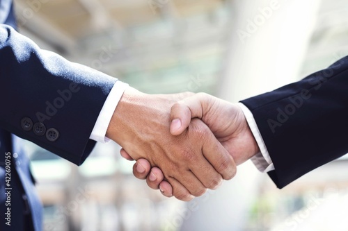 A close-up picture of a businessman shaking hands on a business cooperation agreement in the heart of the city. Concept of Cooperation business and success