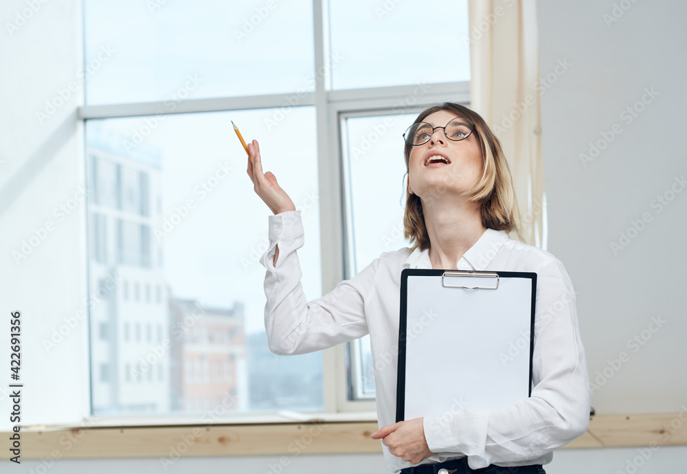 Woman with documents in hands near the window indoors business finance Woman with documents in hands near the window indoors business finance