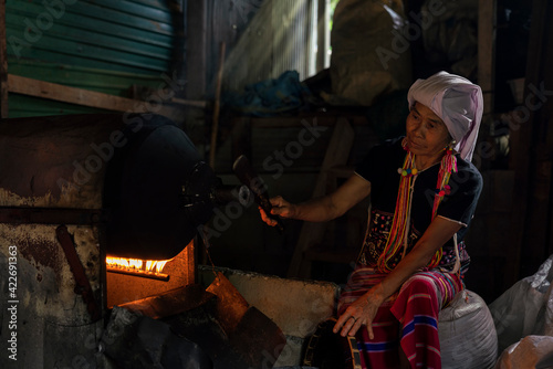 Hill tribe woman roasting coffee. Hill tribe women sorting coffee beans. Old Woman selecting roasted coffee bean. Thailand.