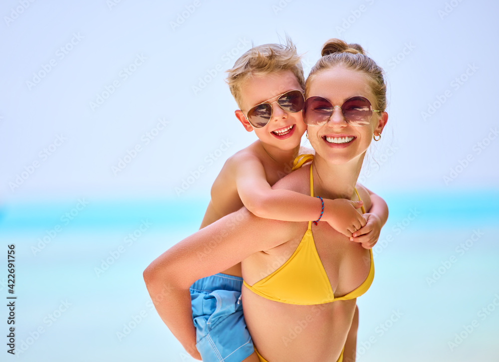 Cheerful mother and son on tropical seashore Cheerful mother and son on tropical seashore