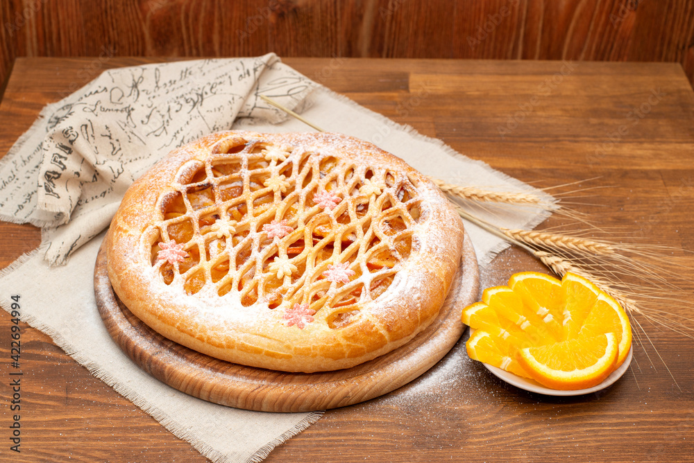 candied fruit pie on a linen towel decorated with candied fruit on a wooden table. Close-up. Homemade baking.