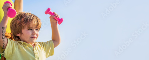 Sporty boy with dumbbells. Sport. Fitness  health and energy. Healthy lifestyle. Cheerful boy do exercises with dumbbells. Fitness child. Kid exercising with dumbbells. Sport for little children