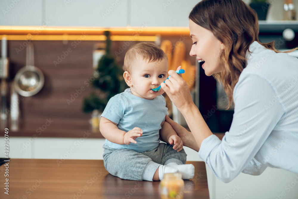Mom feeding the baby with baby food