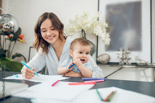 Woman and child drawing with colored felttip pens photo