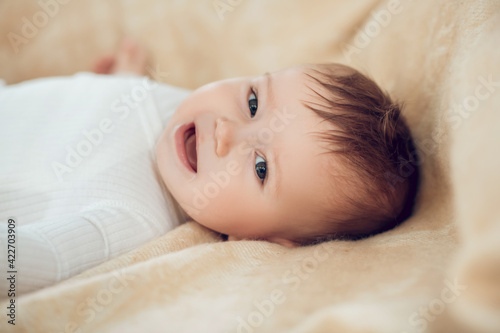 Cheerful smiling kid lying on bed