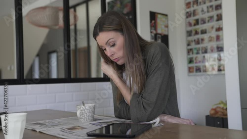 Woman at home relaxing and reading newspaper photo