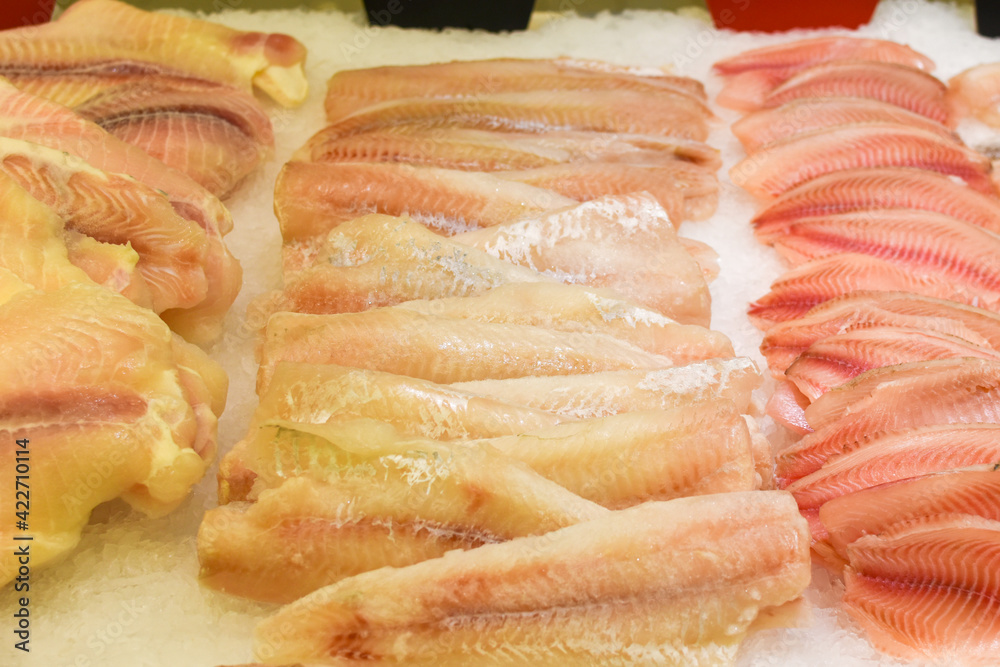 counter with fresh fish in store. Fish fillet on ice. Chilled seafood, raw cod and sea bass fillets on ice at fish market. Healthy foods, source of proteins, vitamins, minerals and omega-3 counter with fresh fish in store. Fish fillet on ice. Chilled seafood, raw cod and sea bass fillets on ice at fish market. Healthy foods, source of proteins, vitamins, minerals and omega-3