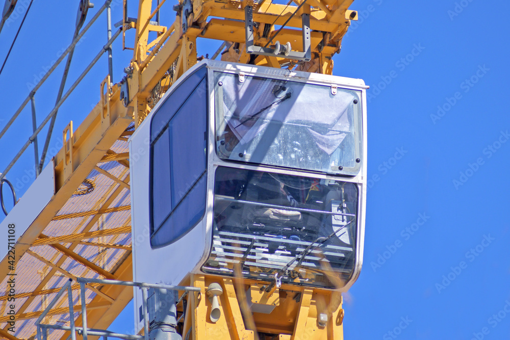 Construction crane cab with operator on blue sky background Stock Photo ...