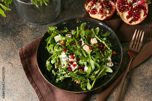 Plate with arugula salad on grunge background