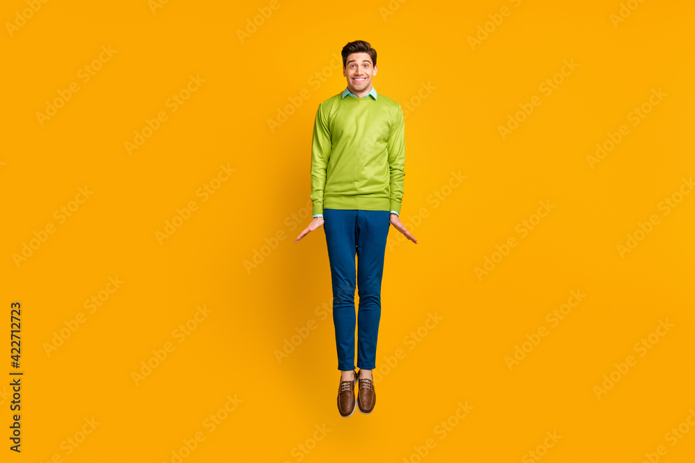 Full length body size profile side view of nice skinny cheerful guy jumping having fun isolated on bright yellow color background Full length body size profile side view of nice skinny cheerful guy jumping having fun isolated on bright yellow color background