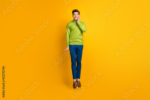 Full length body size profile side view of nice funky glad delighted cheerful guy jumping having fun isolated on bright yellow color background