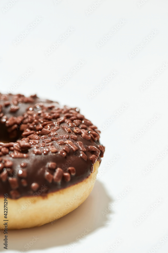 Mmm, so yummy. Close up shot of a freshly baked delicious chocolate donut with sprinkles on white background Mmm, so yummy. Close up shot of a freshly baked delicious chocolate donut with sprinkles on white background