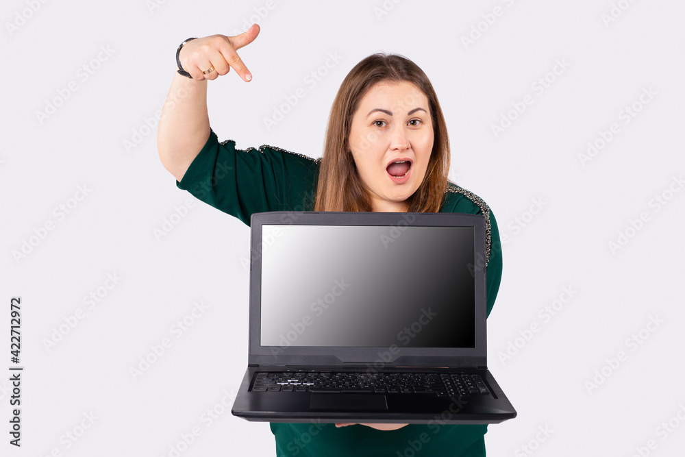 Caucasian plump woman holding laptop computer, pointing with index finger at the screen. Remote work and online business concept. Caucasian plump woman holding laptop computer, pointing with index finger at the screen. Remote work and online business concept.