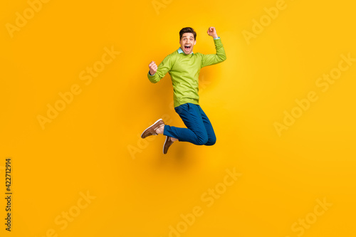 Full length body size profile side view of attractive overjoyed cheerful guy jumping rejoicing isolated on bright yellow color background