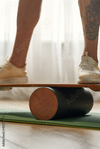 Man in sneakers standing on balance board