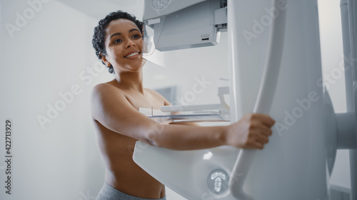 In the Hospital, Happy Smiling Topless Latin Female Patient with Short Hair Undergoing Mammography Screening Procedure. Healthy Young Female Does Cancer Preventive Mammogram Scan in Radiology Room.