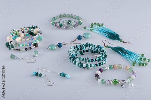 Costume jewelry sets on a light gray background. Earrings and bracelets. 