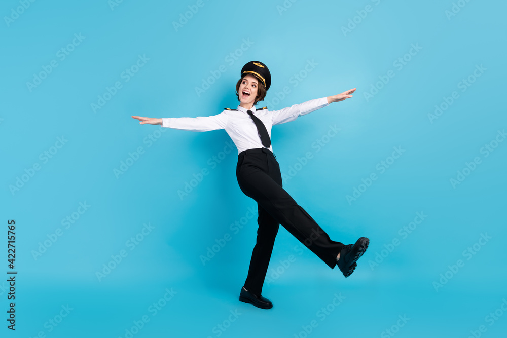 Full length photo of happy nice young woman hold hands plane wings look empty space isolated on blue color background