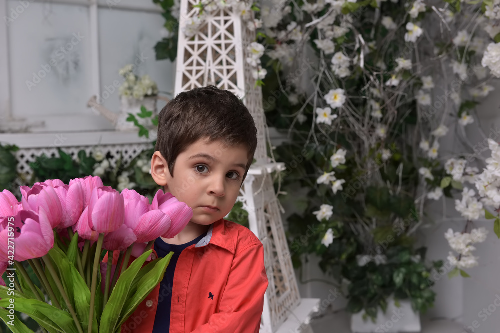 Little boy in a red shirt and a bouquet of tulips in his hands Little boy in a red shirt and a bouquet of tulips in his hands