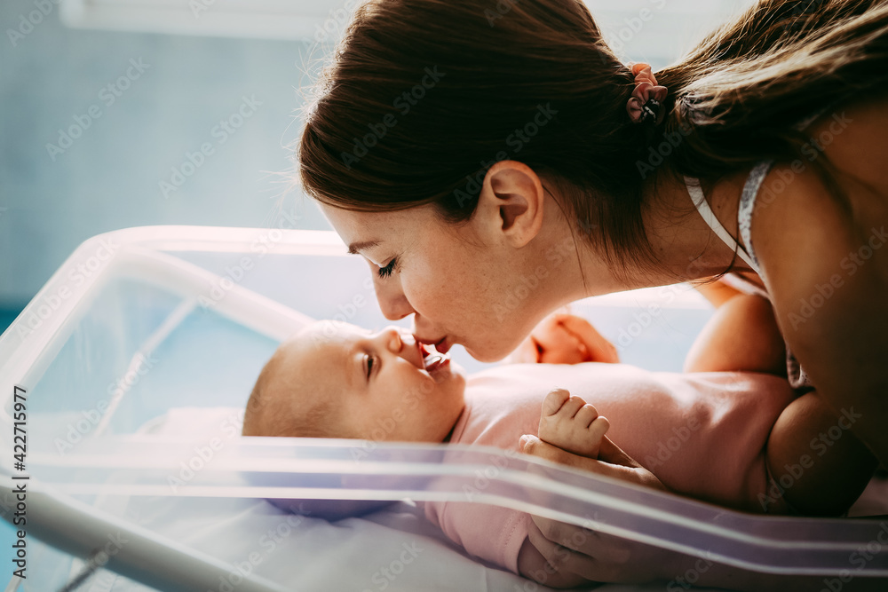 Obraz premium Portrait of beautiful loving mom playing first games with her baby