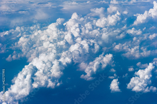 Cumuluswolken am blauen Himmel vom Flugzeugfenster aus gesehen photo