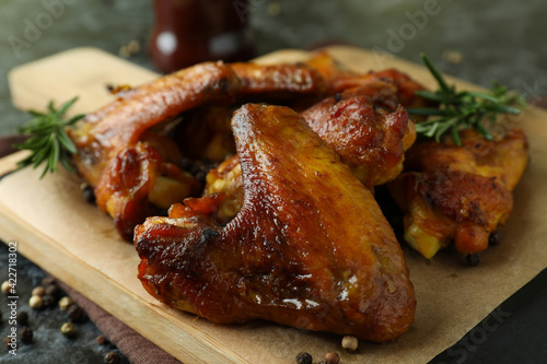 Board with baked chicken wings, close up