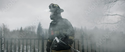 FIXED Hero shot portrait of American male firefighter in full gear standing in the smoke, looking into camera. Shot with 2x anamorphic lens 100 FPS slow motion photo