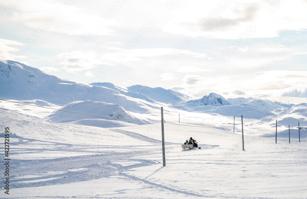 Mountain rescue workers driving a snowmobile in the winter mountains on avalanche patrol. Mountain rescue workers driving a snowmobile in the winter mountains on avalanche patrol.