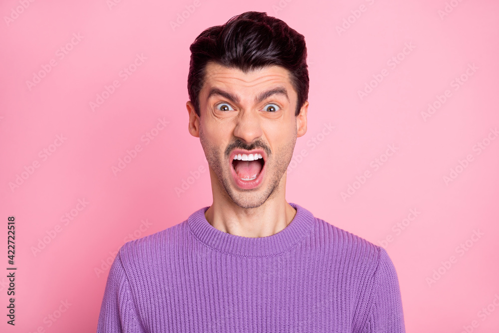 Photo of funky angry young guy wear violet sweater open mouth shouting isolated pink color background Photo of funky angry young guy wear violet sweater open mouth shouting isolated pink color background