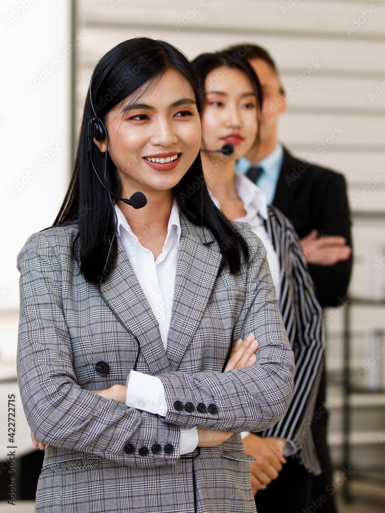 Portrait close-up shot of young pretty confident happy successful asian businesswoman operator wear gray stripe suit stand smiling cross arms in front of male female colleagues in blurred background Portrait close-up shot of young pretty confident happy successful asian businesswoman operator wear gray stripe suit stand smiling cross arms in front of male female colleagues in blurred background