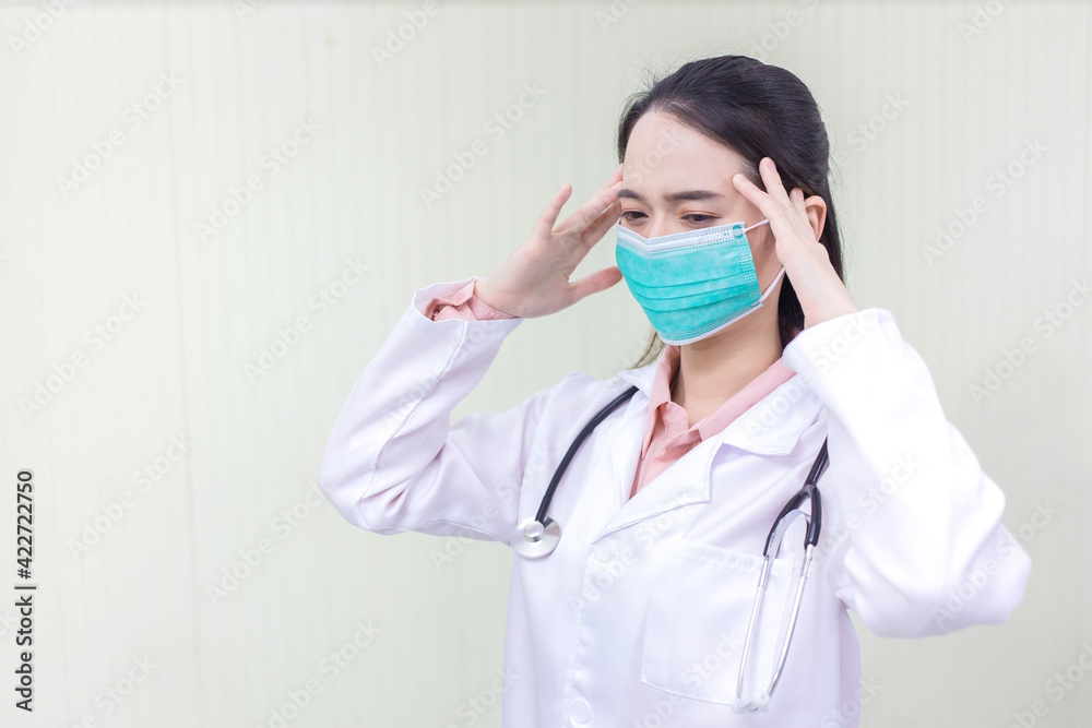 Asian female doctor Sitting in the examination room wearing a mask and pondering in health care,pollution PM2.5,new normal and coronavirus protection concept. Asian female doctor Sitting in the examination room wearing a mask and pondering in health care,pollution PM2.5,new normal and coronavirus protection concept.
