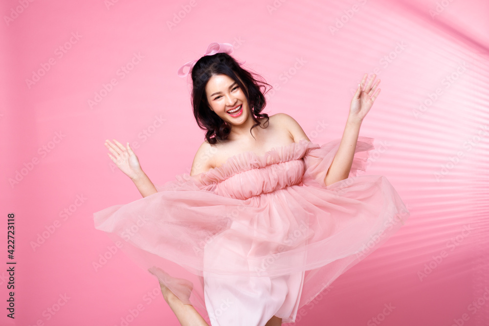 Portrait of Asian girl wear pink dress over pink tone background