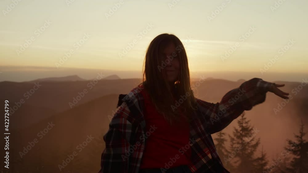 Woman dancing at sunset in mountains. Happy girl making funny moves during dance Woman dancing at sunset in mountains. Happy girl making funny moves during dance