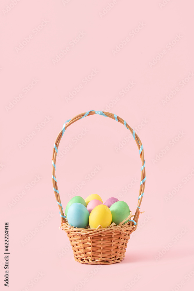 Creative concept of an Easter basket full of pastel colored eggs. Minimal Spring decoration on pink background... Creative concept of an Easter basket full of pastel colored eggs. Minimal Spring decoration on pink background...