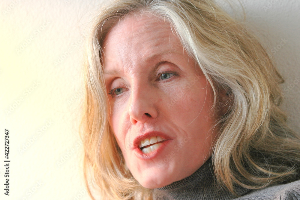 Mature female blond beauty expressions indoors.