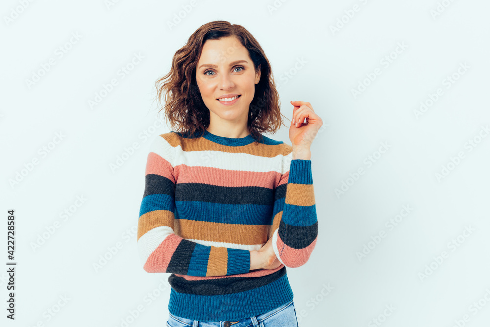 Happy young woman wearing casual sweater and jeans standing on white background Happy young woman wearing casual sweater and jeans standing on white background