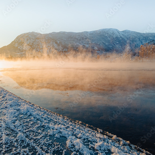 Misty morning with cold smoke on a river photo